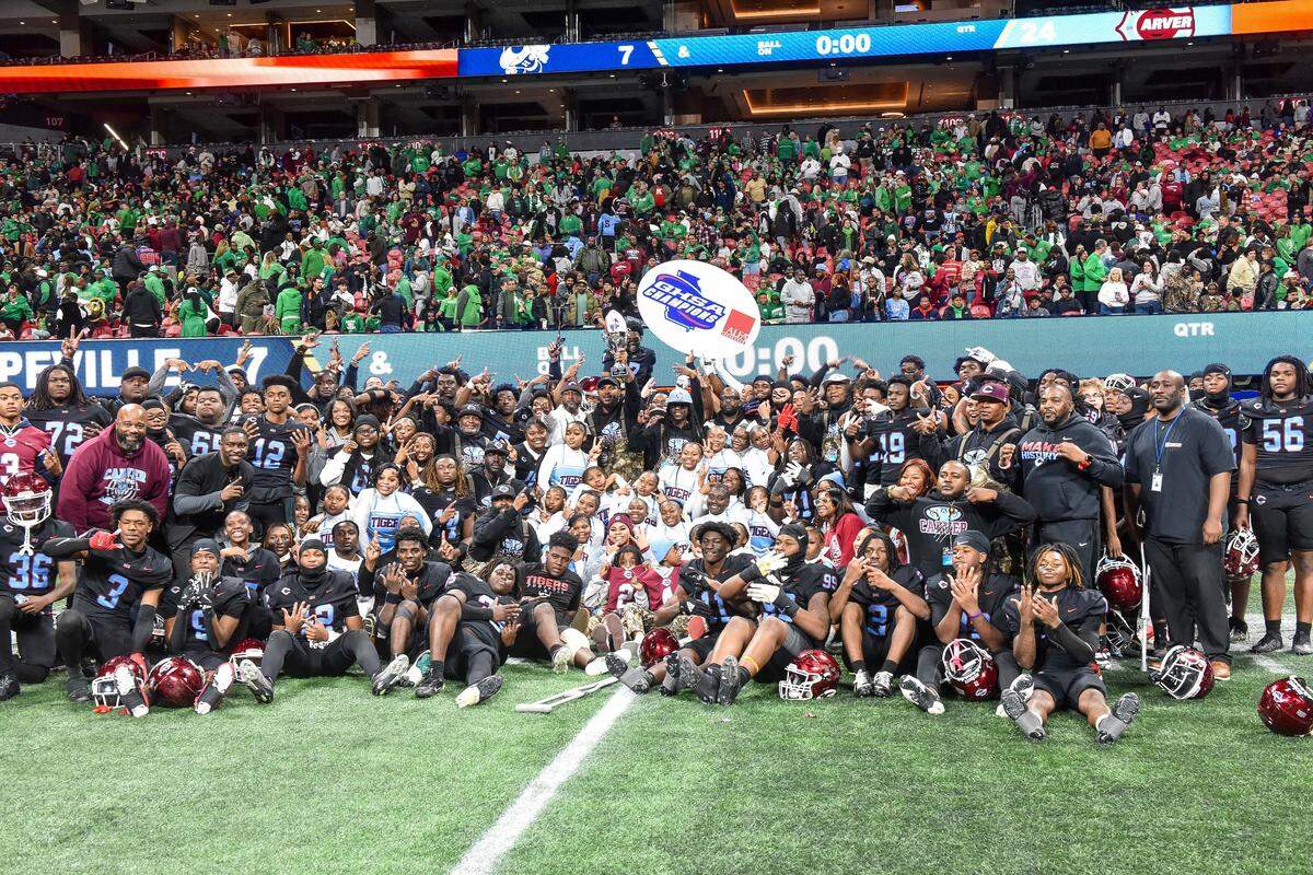 The Carver football team and supporters pose for photographers after the Tigers beat Hapeville Charter 24-7 for the Georgia High School Association Class 2A state championship Dec. 16, 2025, at Mercedes-Benz Stadium in Atlanta.