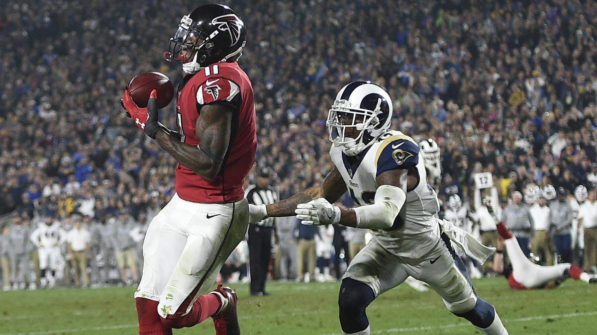 Atlanta Falcons wide receiver Julio Jones, left, catches a touchdown pass ahead of Los Angeles Rams strong safety John Johnson during the second half of an NFL football wild-card playoff game Saturday, Jan. 6, 2018, in Los Angeles