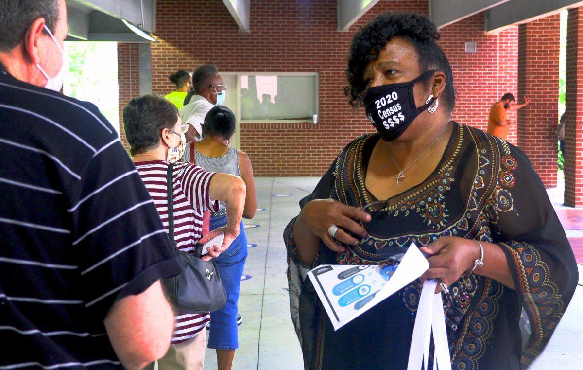 Gloria Strode, right, a partnership specialist with the Atlanta Regional Census Center, asks people waiting in line Tuesday to enter the Citizens Service Center in Columbus, Georgia if they have filled out the 2020 census. Most people in line told Strode they had responded.