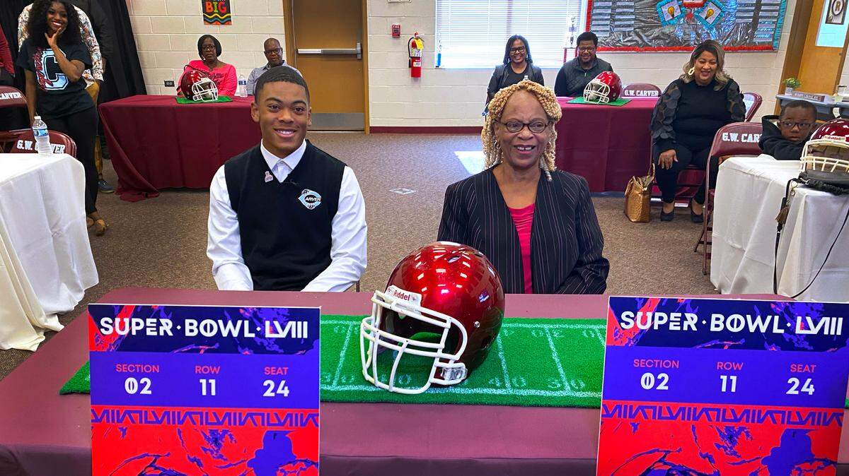 Carver High School junior Braylon Jakes, left, learned during Friday’s assembly that the NFL is providing two tickets for him and a guest to attend Super Bowl LVIII in Las Vegas. Here, Jakes and his grandmother Jacqueline Jakes are answers questions after the event. 11/03/2023