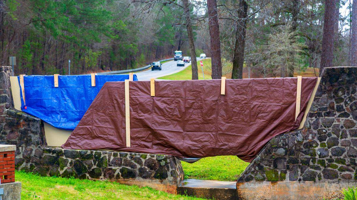 The stone gate entrance sign that welcomed people to Fort Moore is covered with tarps March 5, 2025, now that the U.S. Army post next to Columbus has been renamed back to Fort Benning. This entrance is on Ft. Benning Road.