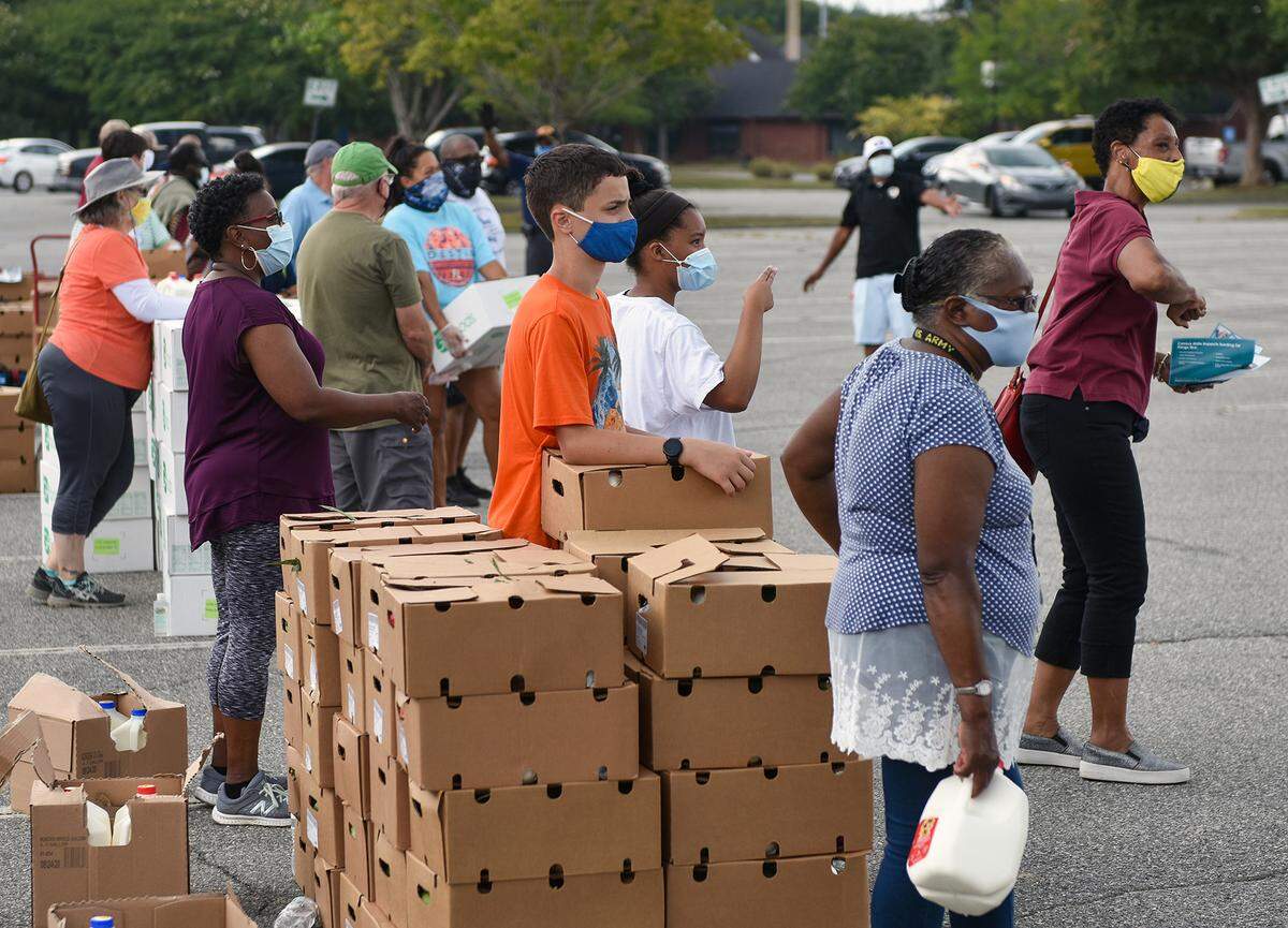Volunteers prepare to load boxes of meats, vegetables, and dairy products into cars during the Community Food Giveaway at the Columbus Civic Center parking lot Saturday afternoon, August 8, 2020 in Columbus, Georgia.