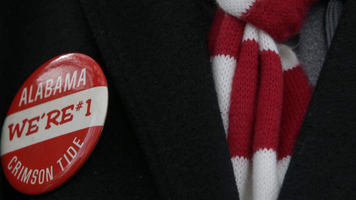 An Alabama football fan wears a button proclaiming their national championship, Saturday, Jan. 23, 2016, in Tuscaloosa, Ala. Alabama fans turned out by the thousands to celebrate the Crimson Tide's fourth national championship in seven years. (AP Photo/Hal Yeager)