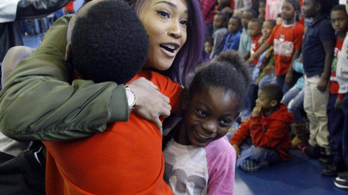 Photos by ROBIN TRIMARCHI/rtrimarchi@ledger-enquirer.comAlex Johnson of the Levi Johnson girl group gets hugs from youngsters at the Cusseta Road Boys & Girls Club on Friday. The pop trio visited the club with other artists performing with Chris Brown at the Columbus Civic Center on Saturday.