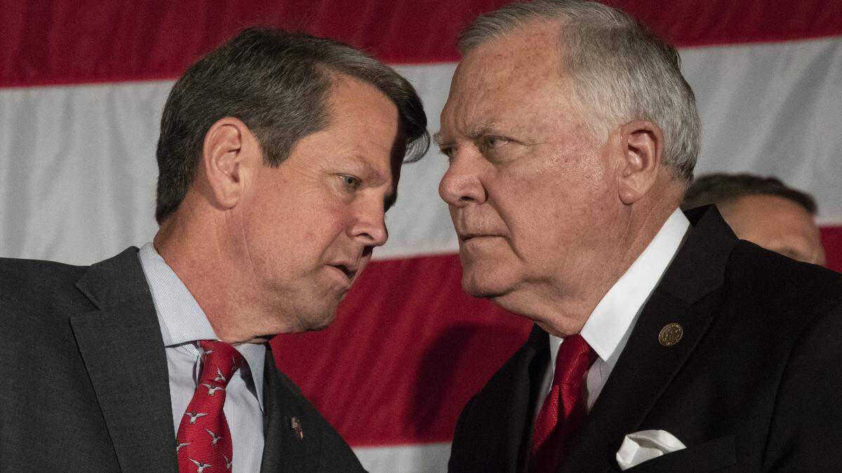 Georgia Secretary of State and Republican gubernatorial nominee Brian Kemp, left, talks to outgoing Gov. Nathan Deal during a unity rally July 26 in Peachtree Corners.