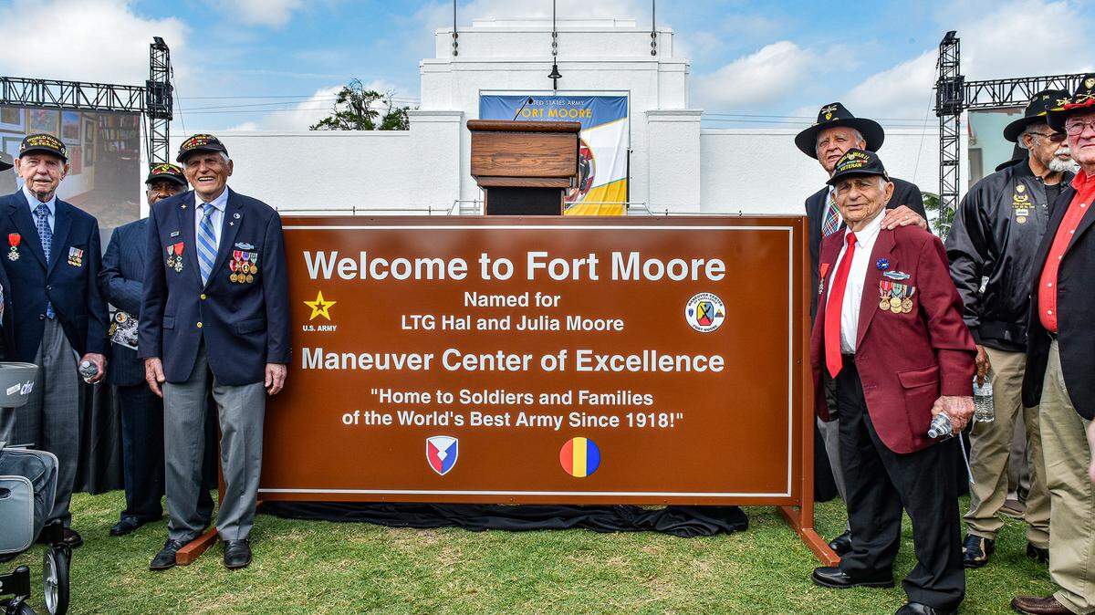 World War II veterans and Vietnam Veterans, including veterans from Hal Moore’s unit in Vietnam, pose next to the new post sign at the end of the ceremony changing the name of Fort Benning to Fort Moore in honor of Lt. Gen. Hal and Julia Moore on Mary 11, 2023