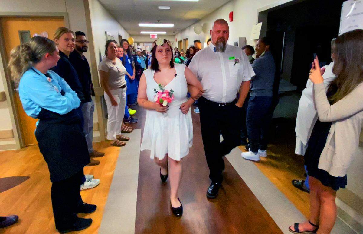 Heather Renee Duke is escorted down a hall lined with family, friends, and well-wishers Wednesday afternoon during her wedding to Alexander Ramirez Santos at Piedmont Columbus Regional’s Midtown Campus. 07/20/2023