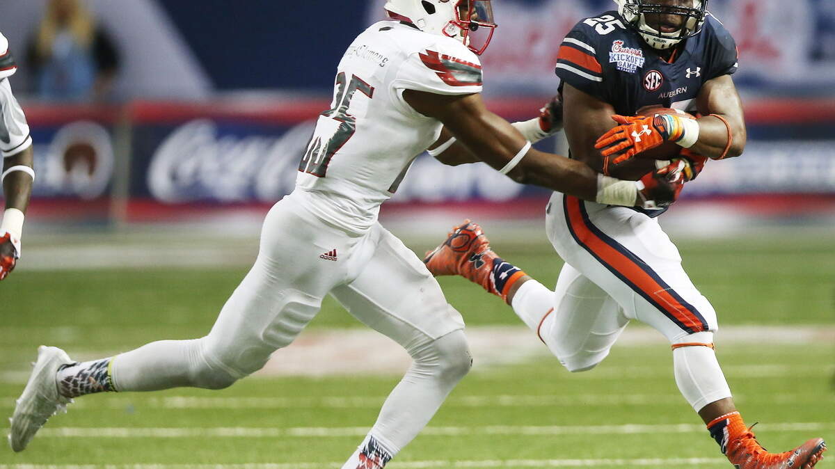 JOHN BAZEMORE/Associated PressAuburn running back Peyton Barber (25) runs by Louisville safety Josh Harvey-Clemons (25) Saturday in Atlanta.
