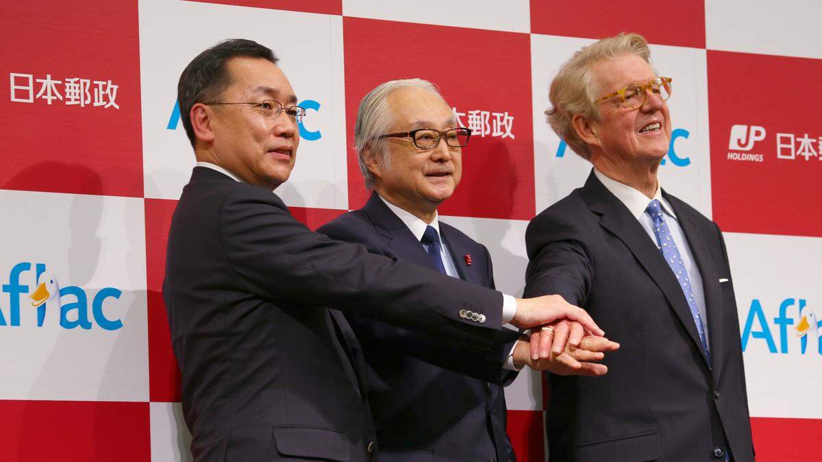 Taking part in a “Unity Handshake” at a press conference Wednesday in Tokyo, Japan, are (l-r) Masatoshi Koide, president and representative director of Aflac Life Insurance Japan Ltd., Masatsugu Nagato, president and chief executive officer of Japan Post Holdings, and Dan Amos, chairman and CEO of Columbus-based Aflac Inc. --