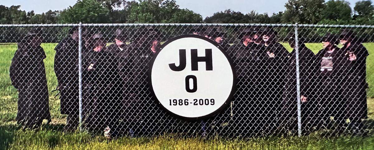 Miracle Riders gather behind a sign on the campus of Missouri Southern State University next to a sign honoring Jonathan Hansen, a soccer player at Missouri Southern who died in February 2009 after collapsing on the court during an intramural basketball game on campus. Then 22, Jonathan was a senior goalkeeper on the men’s soccer team. His father, Brad Hansen, is a Miracle Rider.