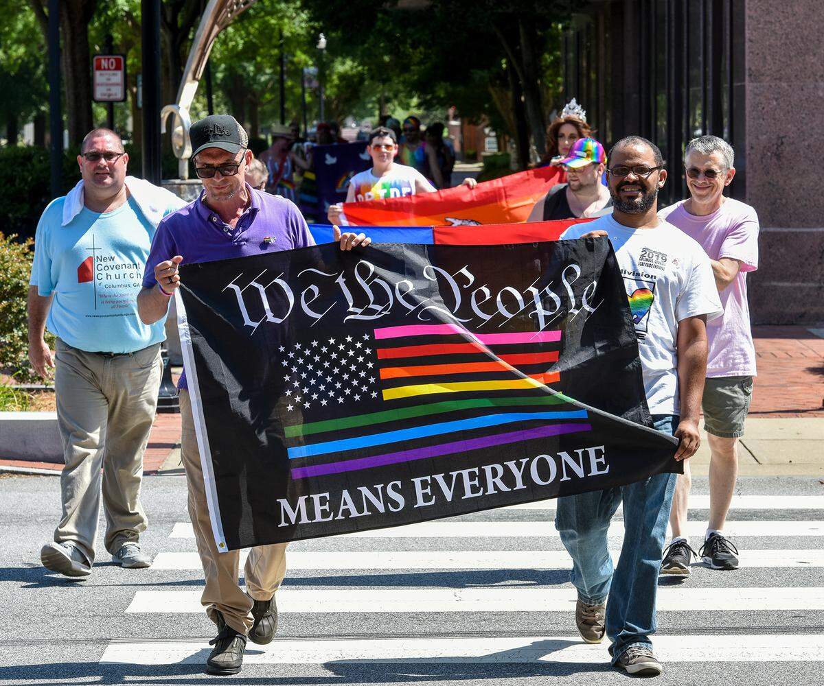 Jeremey Hobbs and Harry Underwood carry the We the People flag while leading a group of marchers along the sidewalks of Broadway during 2019 LGBT Pride Festival parade Saturday afternoon. Colgay Pride hosted a series of events as part of the 2019 LGBT Pride Festival in Columbus, Georgia, starting with a Mr. and Ms. Columbus Georgia Pride Pageant Friday evening and concluding Sunday with the festival’s family day. Four people received awards Saturday at the festival. Former Columbus Mayor and U.S. Senate Candidate Teresa Tomlinson received the Lifetime Achievement Leadership Award. David Brazil (aka Blaze Starr) received the Lifetime Achievement Award in Entertainment and Mentoring. Harry Underwood was named the LGBT Pioneer of the Year, and Raymond Chambless was recognized for his “selfless service.”