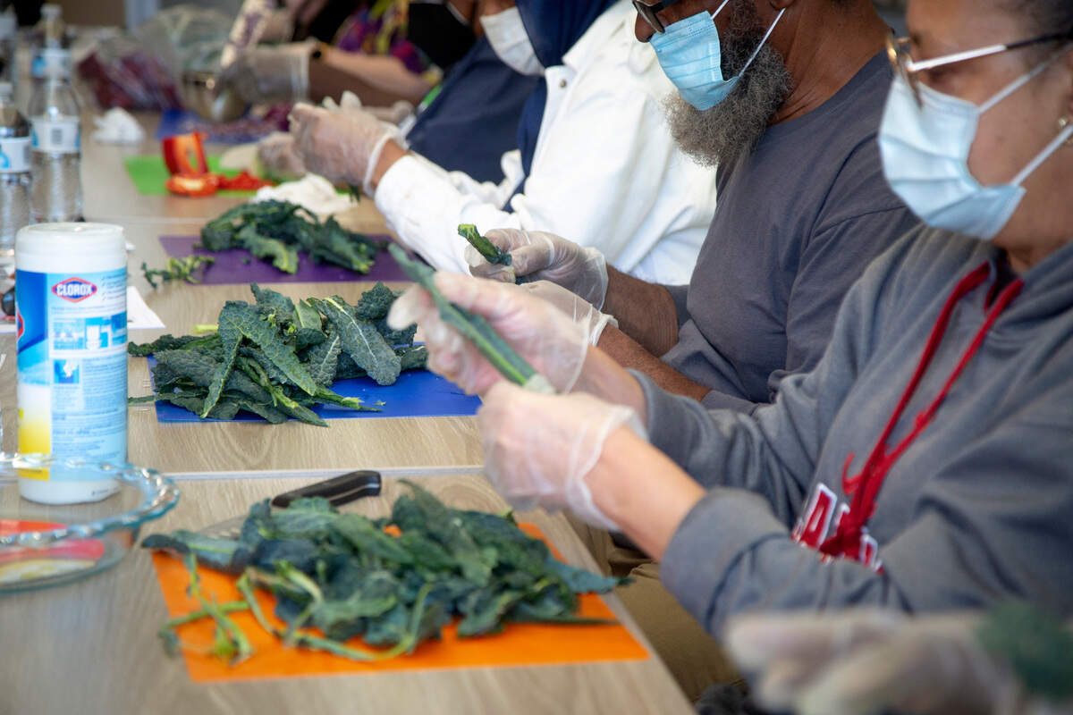 Class participants de-stem dinosaur kale during a “Cooking Matters” course at The Food Mill in Columbus, Ga. on March 14, 2022. The course is designed to teach sustainable and affordable cooking practices.