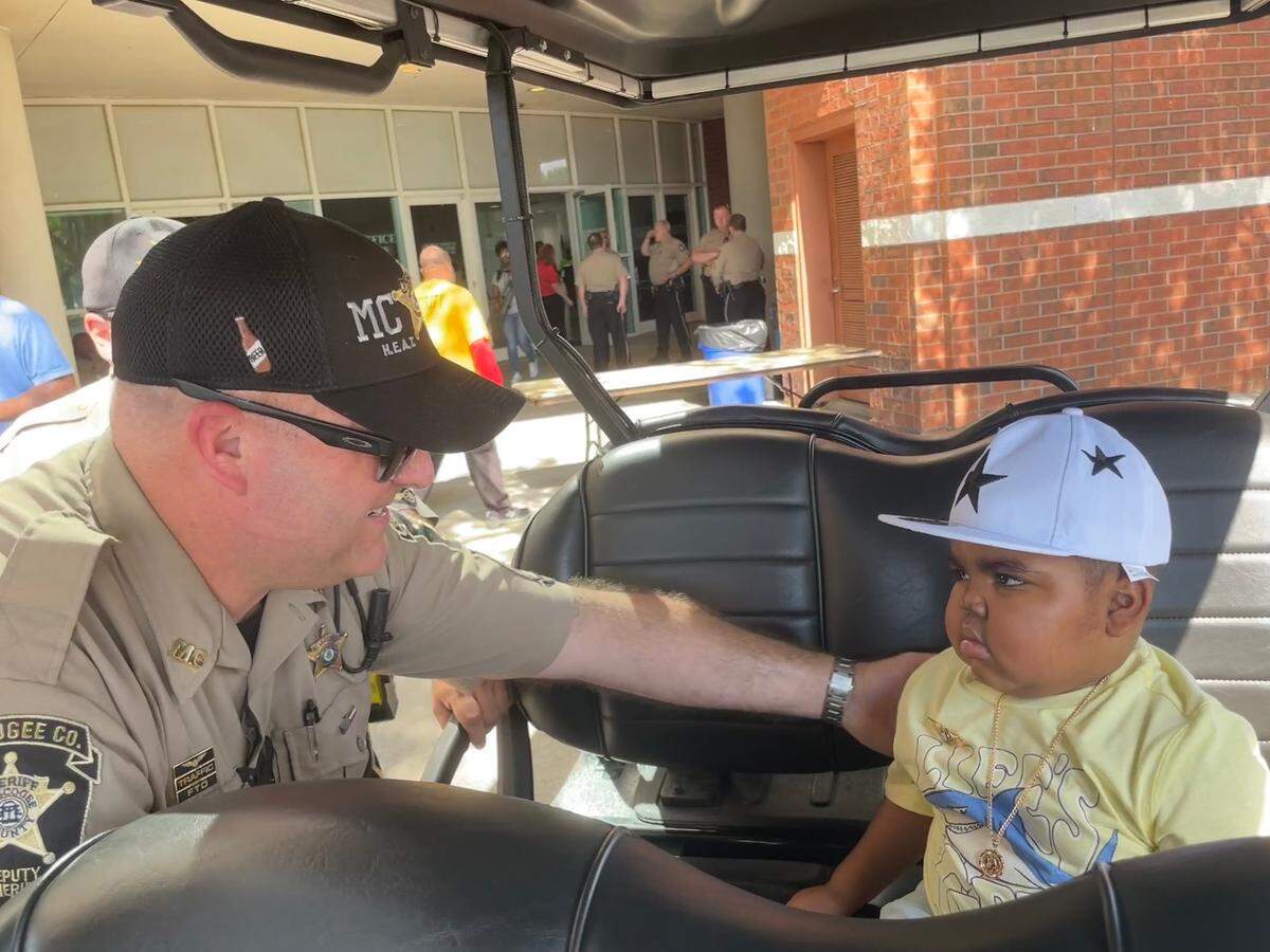 Armon is given a sheriff pin by a sheriff’s deputy.