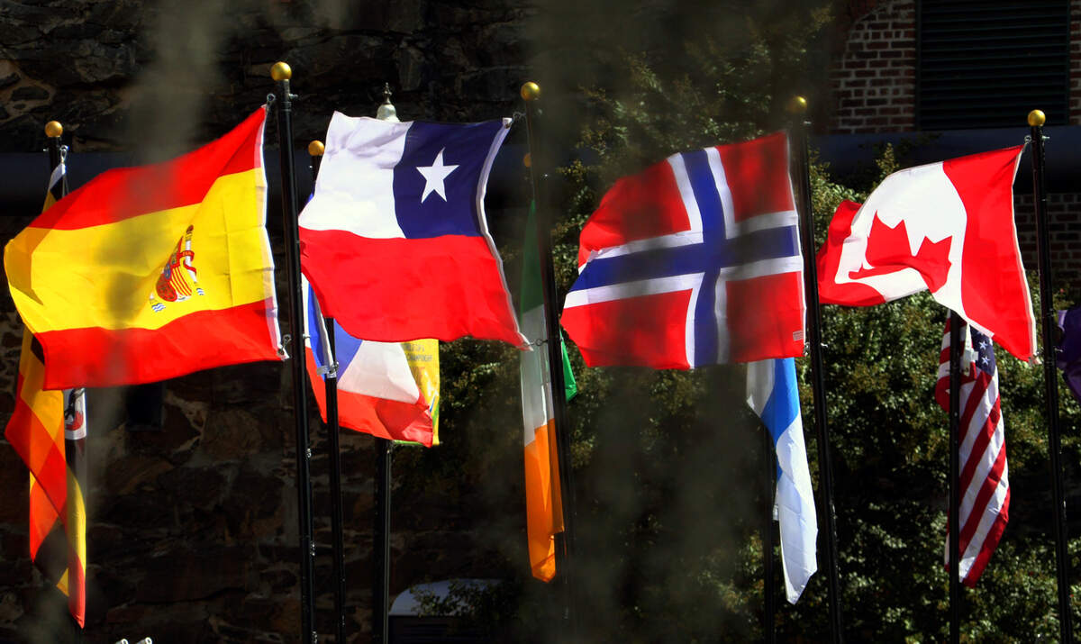 Flags representing the competitors in the 2023 ICF Canoe Freestyle World Championships line the bridge to Waveshaper Island. 10/05/2023