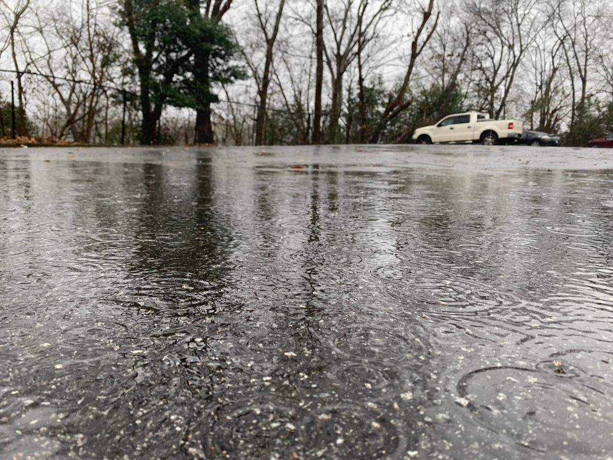 Rain falls into a puddle in a parking lot in Columbus.