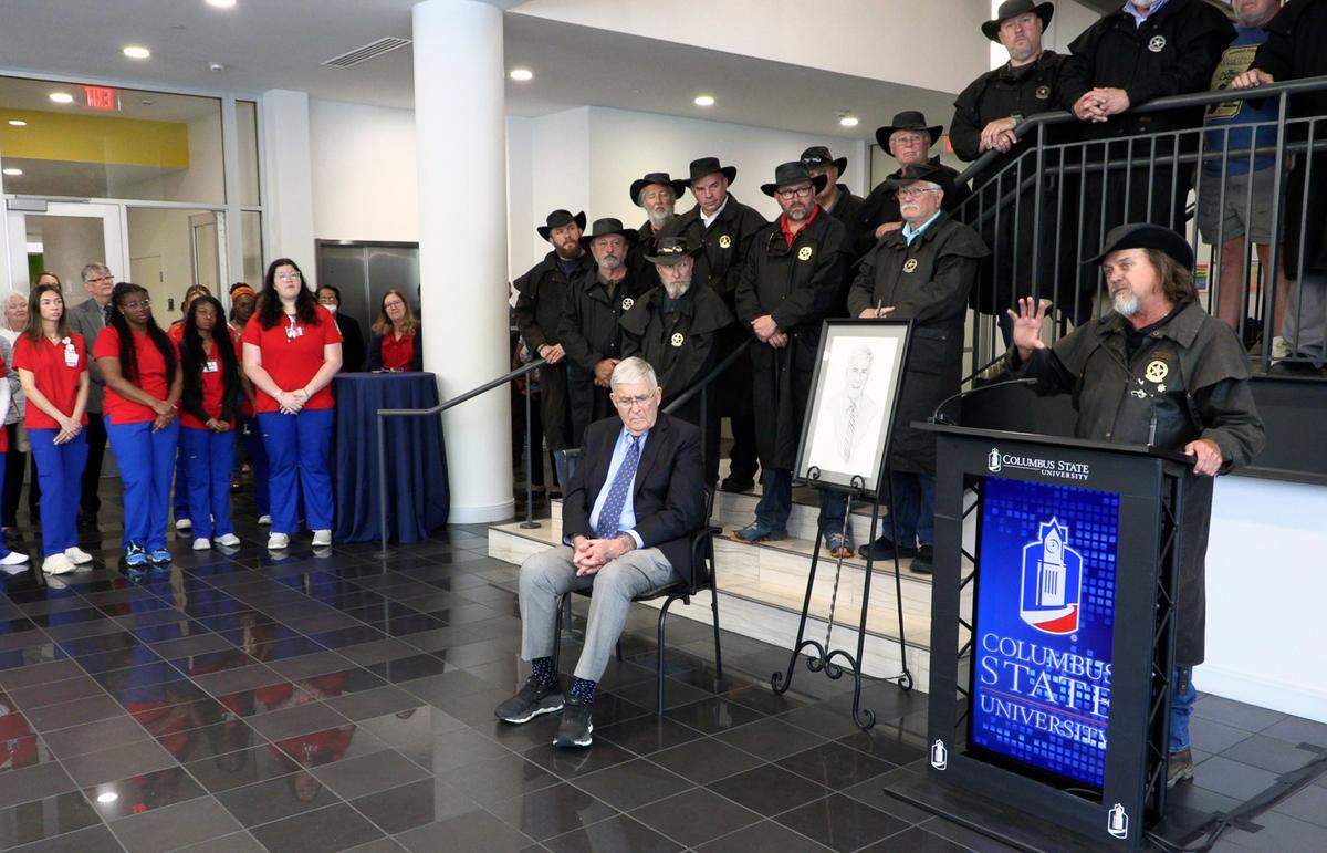 Scott Ressmeyer, co-owner of Country’s Barbecue and founder of the Miracle Ride, speaks Thursday afternoon during a celebration of the new mother-baby simulation lab at Columbus State University’s School of Nursing. The simulation has been named in honor of Dr. Cecil F. Whitaker, M.D., seated. Whitaker is a retired OB-GYN. 03/28/2024