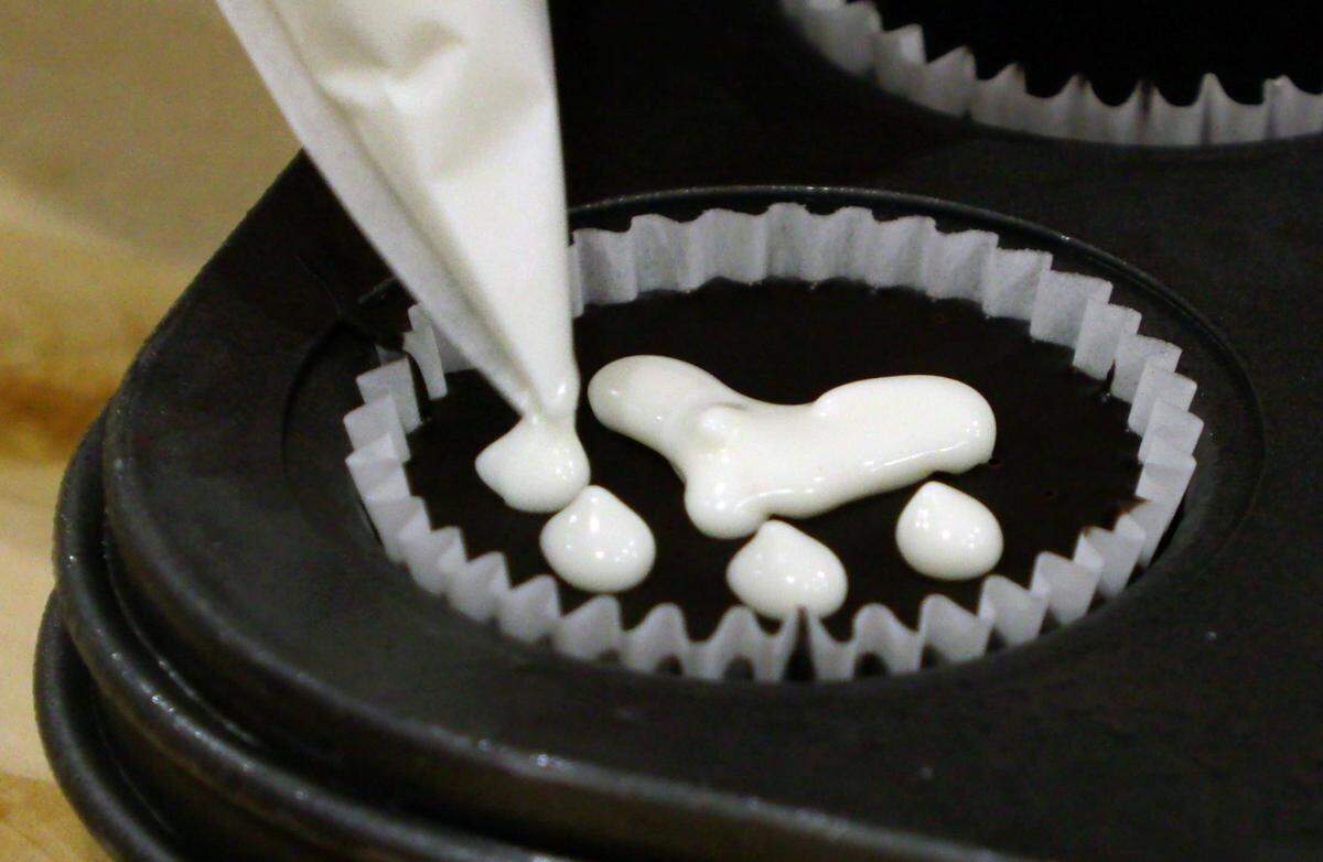Tracy St. John decorates a fresh batch of dog treats Friday morning at Three Dog Bakery, at 1106 Broadway in downtown Columbus, Georgia. Three Dog Bakery offers fresh baked treats made in-house. 04/19/2024