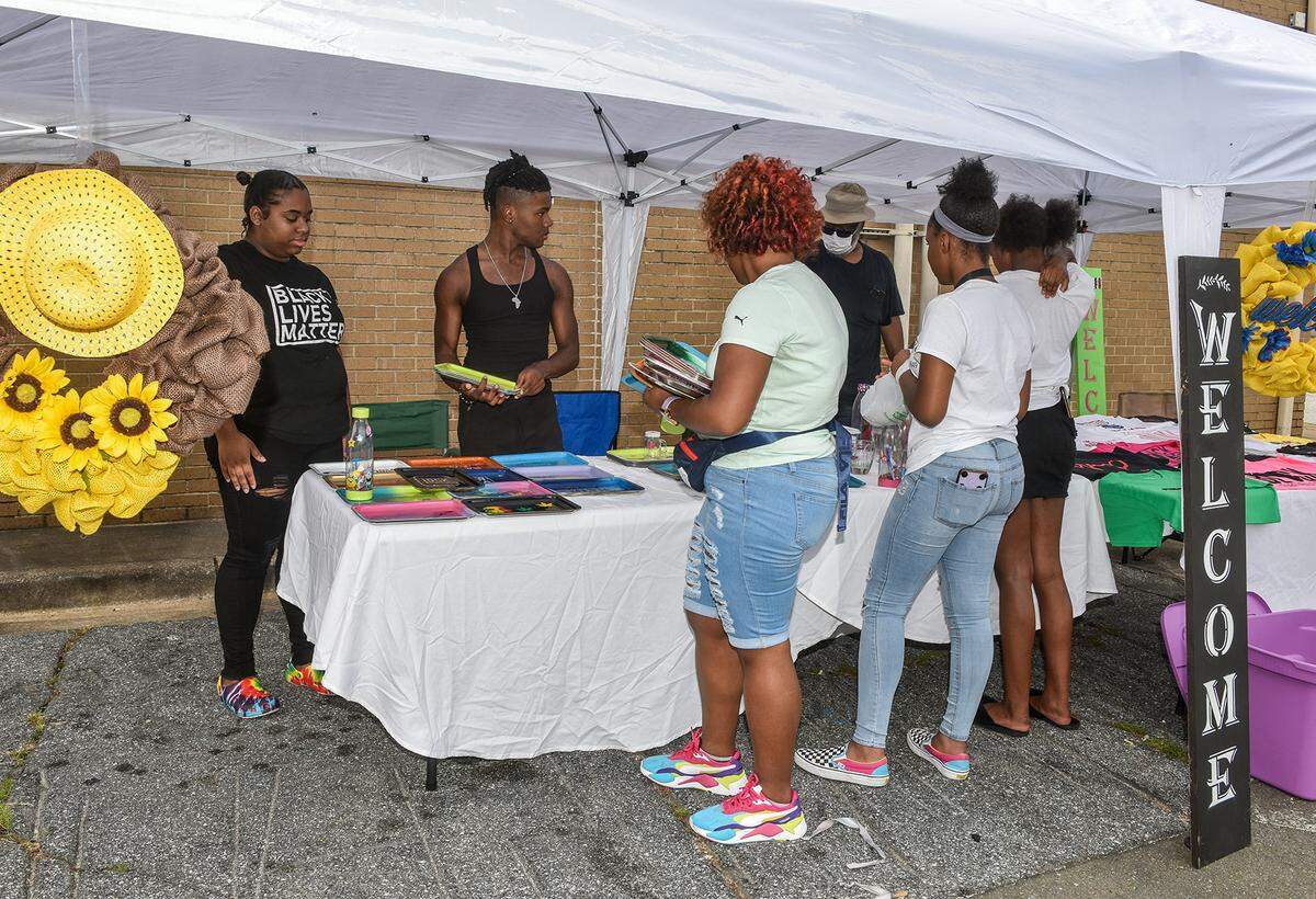 Volunteers set up the Craftin Creations booth for the Juneteenth Celebration Reloaded event Friday evening, June 26, 2020.