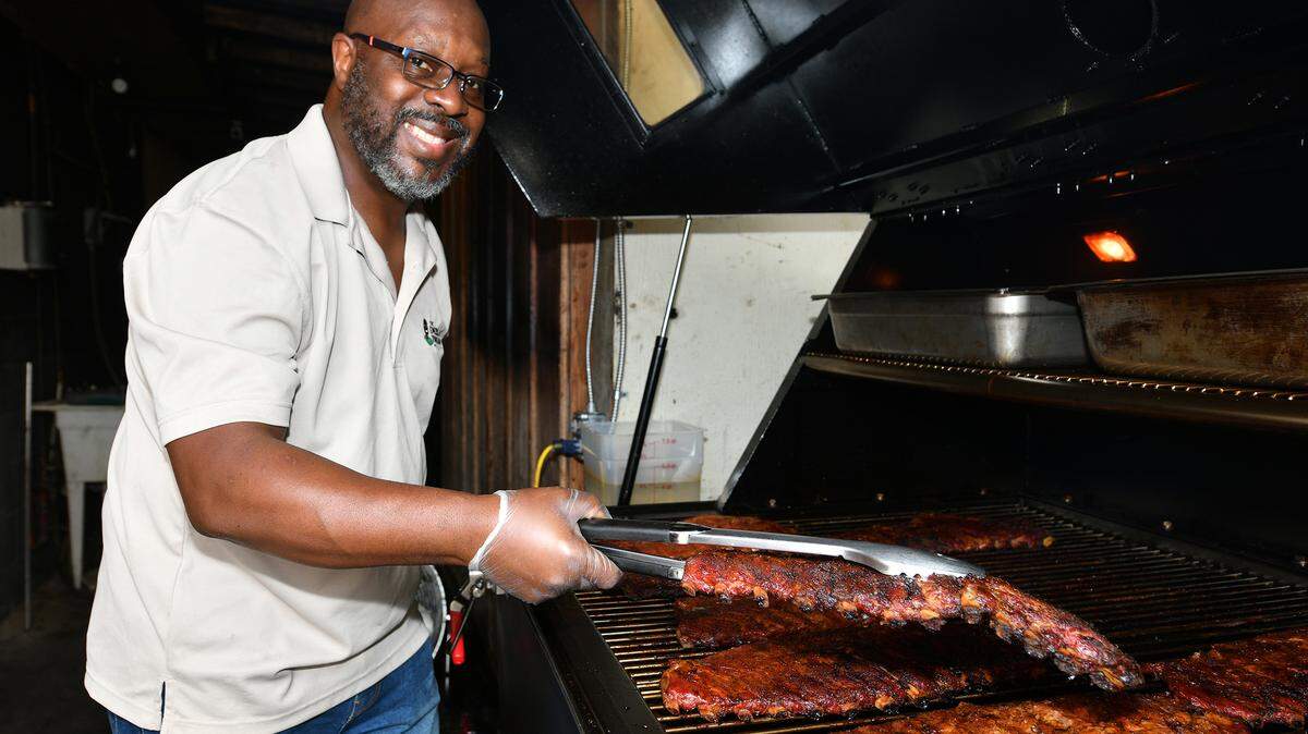 Prathan Powell of Emeralds Touch Barbecue checks the ribs in his BBQ pit