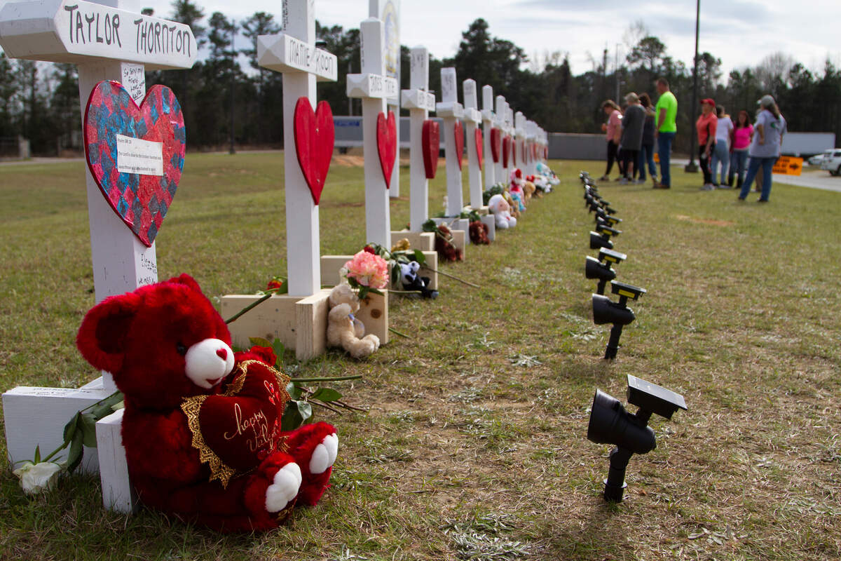 People visit the crosses of the people killed by the tornado outbreak of Sunday, March 3, 2019, in Beauregard, Ala. President Trump and Melania Trump visited the crosses when they were in Beauregard, Ala., on Friday.