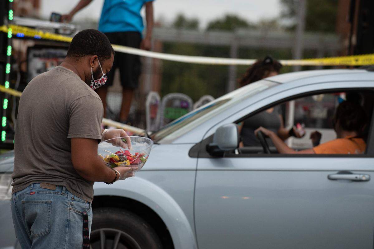 A volunteer passes out candy during the Spooktacular Trunk or Treat event on Sunday, Oct. 25, 2020 at the Civic Center in Columbus.