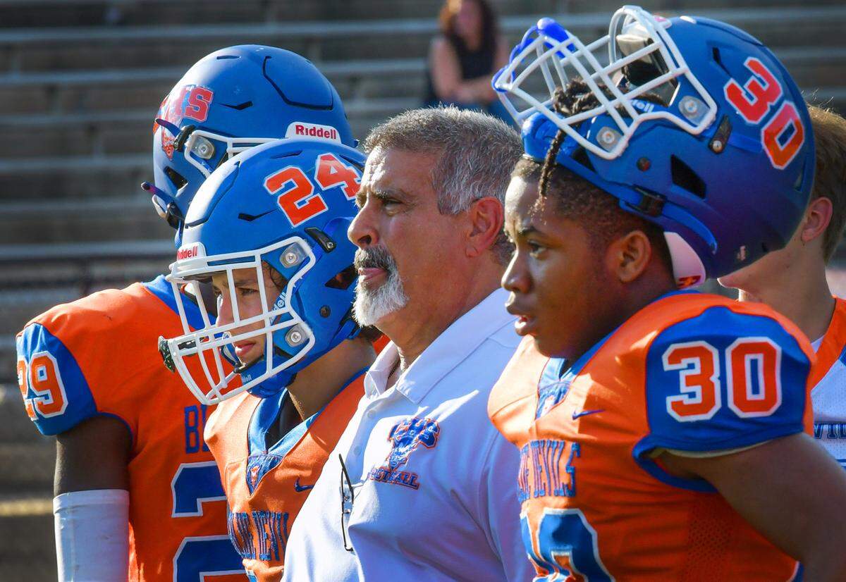 Phil Marino, head football coach at Columbus High School, stands with the Blue Devils on the sideline during their game Aug. 18, 2023.