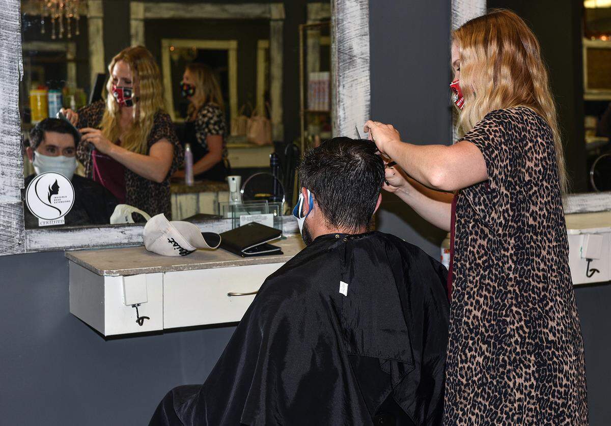 Callie Burelson gives Chris Pose a haircut Friday morning at the Southern Glam Salon and Boutique in Columbus, Georgia on the first day of the re-opening under the guidelines from Georgia Gov. Brian Kemp, Friday, April 24, 2020