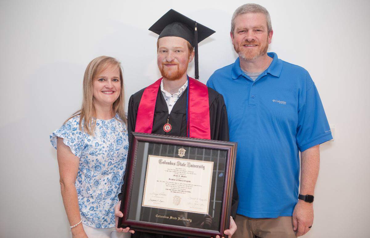 Harris County High School graduate Grant Martin poses in May 2024 with his parents, Amy and Phil, after graduating from Columbus State University in a personalized ceremony at Emory University Hospital in Atlanta, where he waited for a heart transplant. He had studied to become a high school English teacher with plans to join his father at Calvary Christian School before he died in July 2024 at the age of 24 due to complications from the heart transplant. The Martins are establishing a scholarship fund at CSU in Grant’s name.