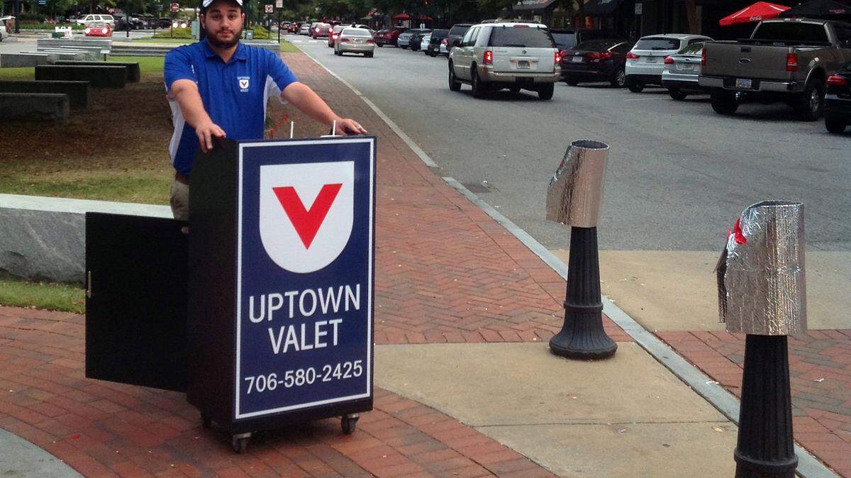Photos by Chuck Williams/chwilliams@ledger-enquirer.comUptown Valet manager Jackson Collins awaits customers on Saturday. Uptown Valet has been in operation for about six weeks. The company offers valet parking for downtown Columbus on Thursdays, Fridays and Saturdays from 5:30-11 p.m.
