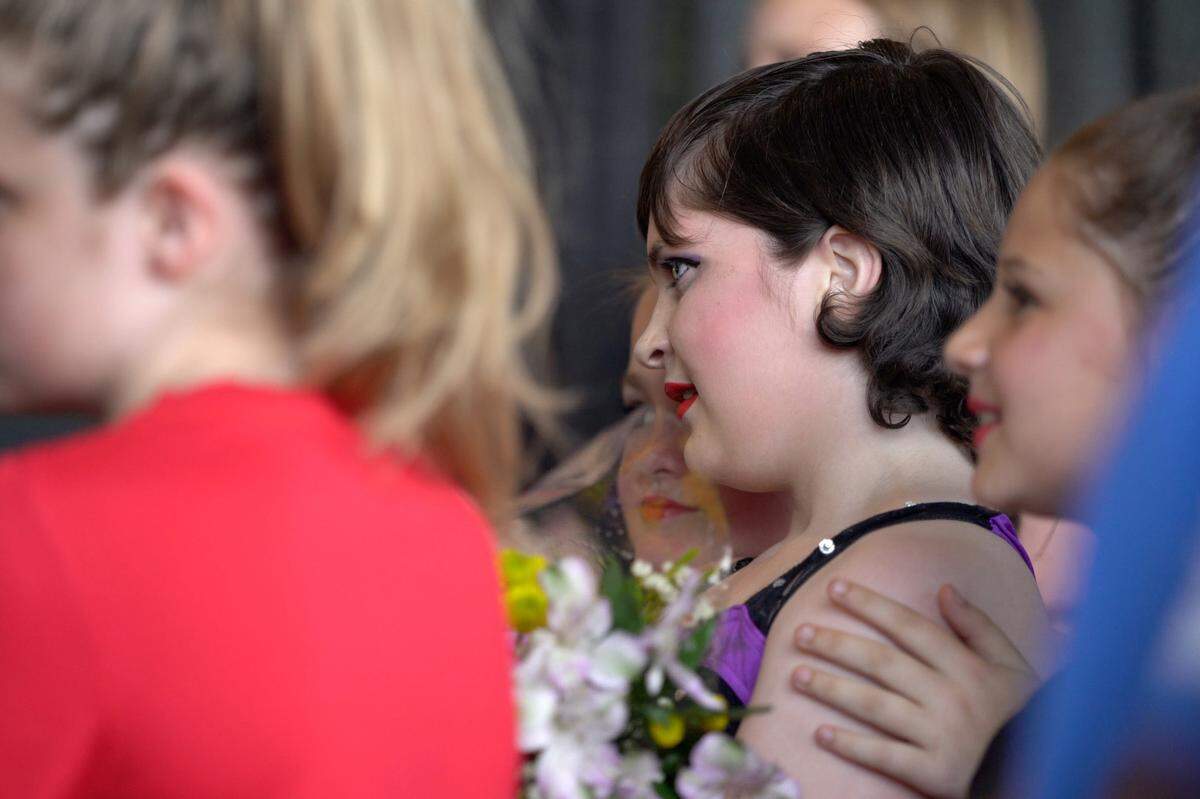 Lexy McRae watches another performance behind stage during her first dance recital, on May 29, 2021, since an osteosarcoma diagnosis, at the Harley Davidson store in Columbus, Ga.