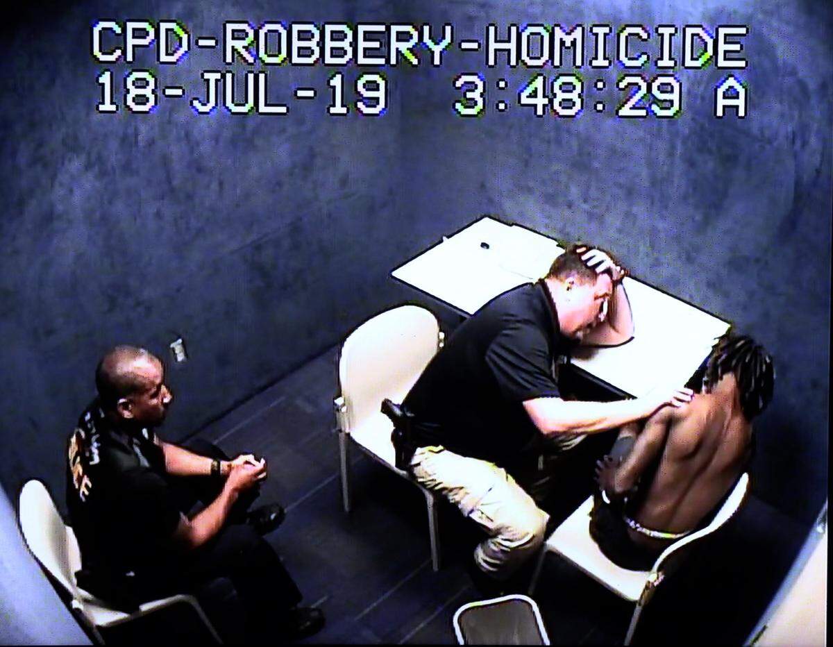Detective Stuart Carter with the Columbus Police Department, center, questions Travane Brandon Jackson, right, on July 18, 2019. Jackson was charged with stabbing to death his three young children and the childrens’ mother.