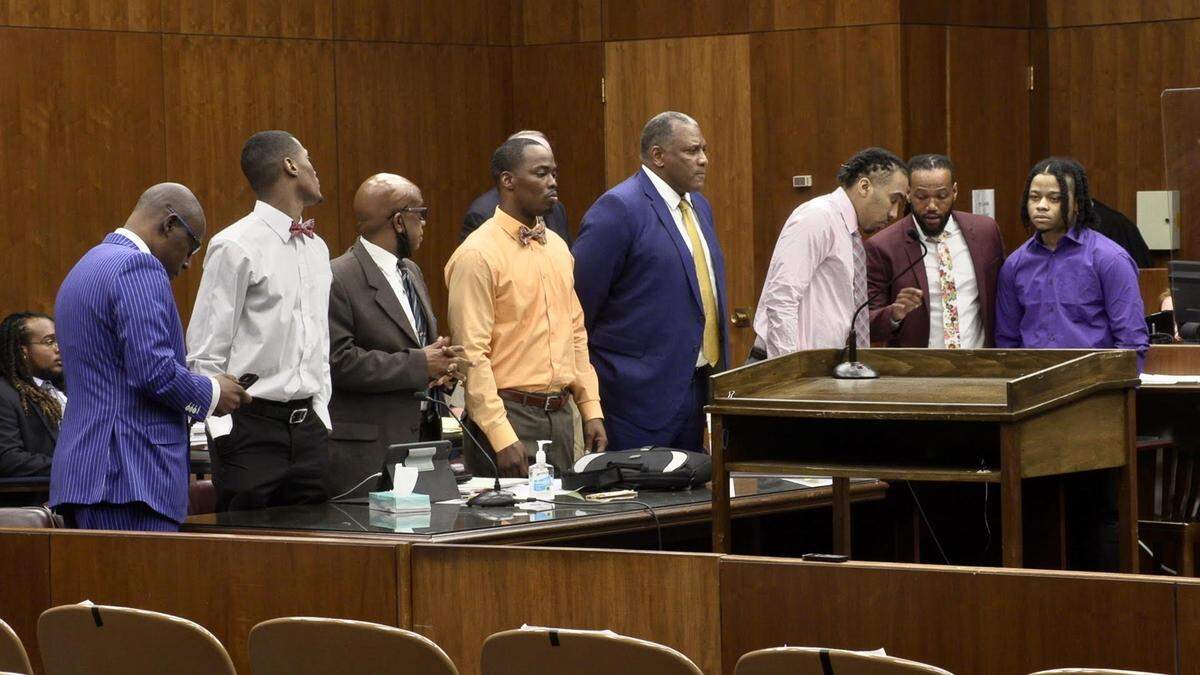 The defendants and their attorneys stand as Senior Judge David Emerson leaves the courtroom to decide on defense motions to acquit the suspects for lack of evidence.