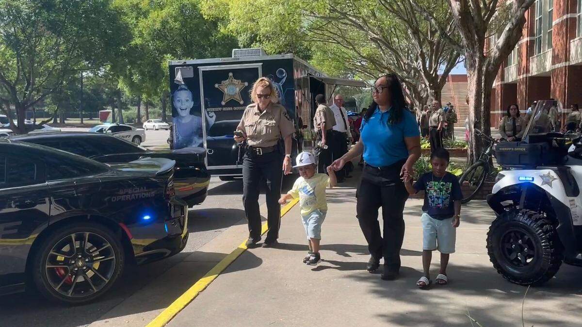 Armon (left) and his brother Ashton (right) tour the array of cars brought by the Sheriff’s Office.