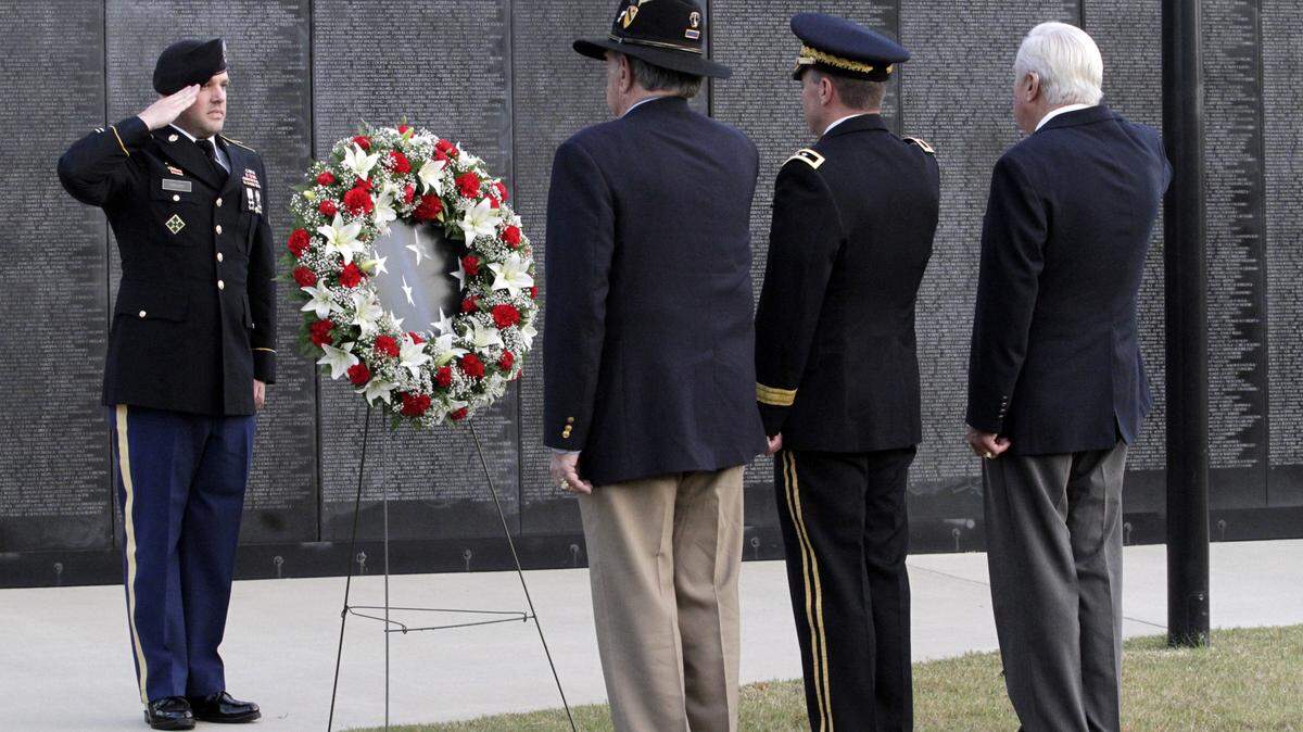 Photos by ROBIN TRIMARCHI/rtrimarchi@ledger-enquirer.comStaff Sgt. Hagan, far left, presents the wreath to Maj. Gen. Scott Miller, center, retired Col. Tony Nadal, center left, and retired Maj. Joel Sugdinis to dedicate the Dignity Memorial Wall at the National Infantry Museum & Soldier Center on Tuesday.
