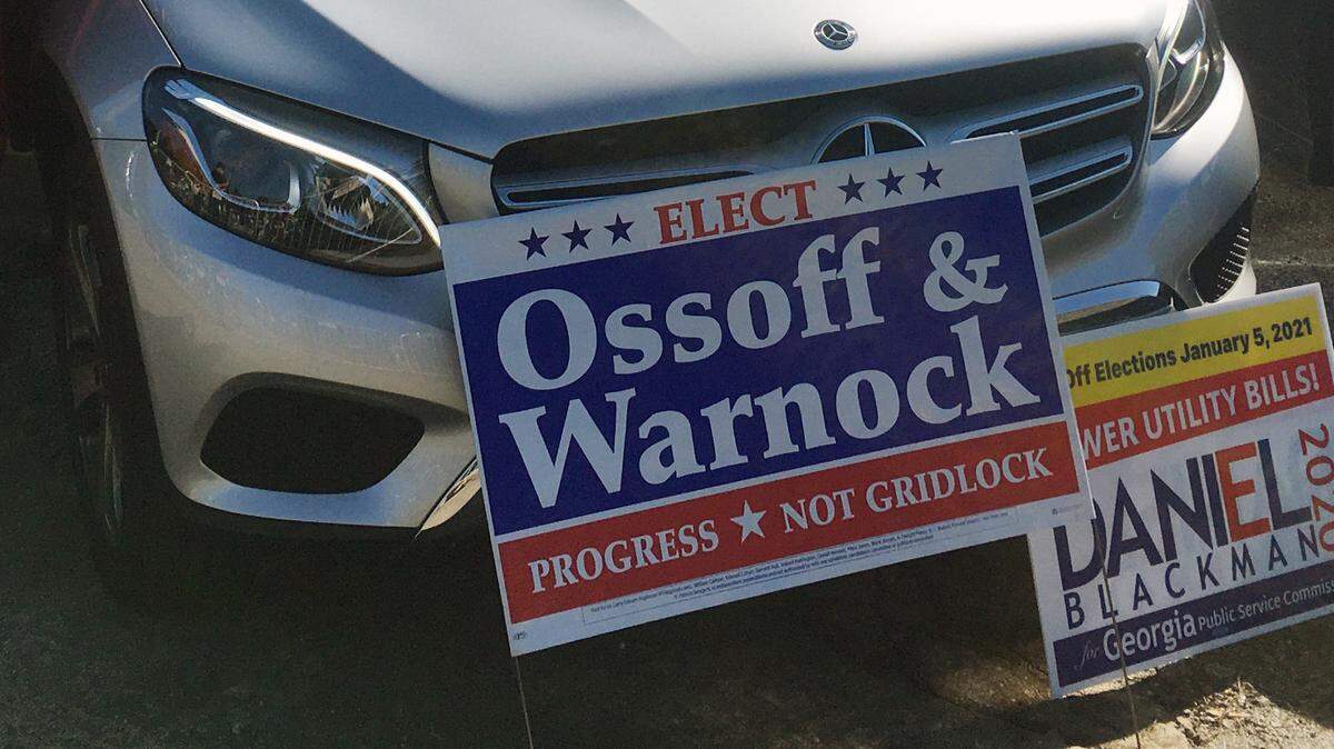 Gladys Ford, 78, adds a Jon Ossoff campaign sign to her vehicle Monday prior to a rally in Columbus, Georgia for Ossoff and Raphael Warnock that featured U.S. Vice President-elect Kamala Harris.