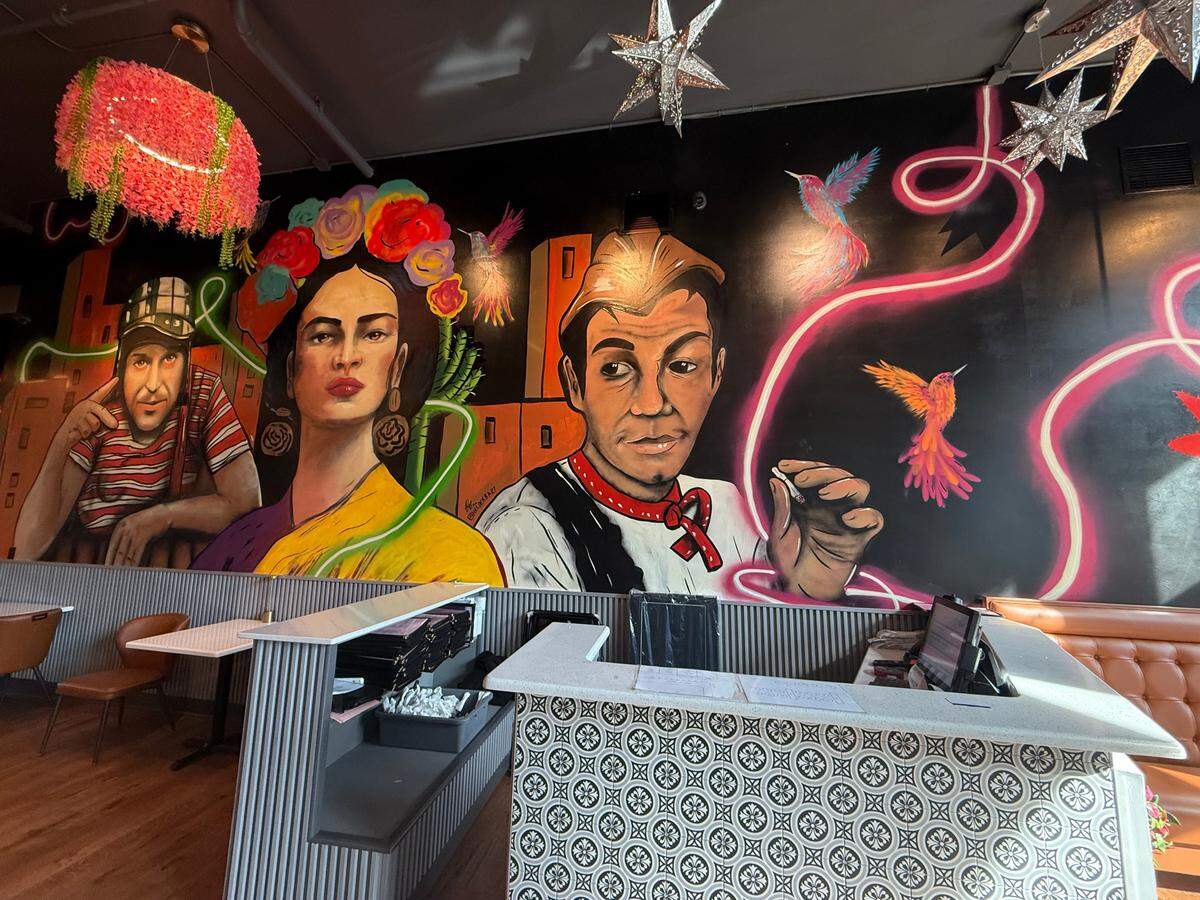 The design of Me Encanta, a new Mexican restaurant at 1231 Broadway in Columbus, captures nods to Mexican culture through a hand-painted mural and portraits of famous figures like Frida Kahlo and Roberto Gómez Bolaños.