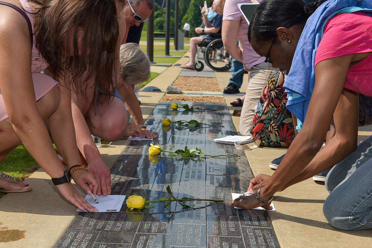 Visitors making rubbings of the paving stones of their relatives and friends during the Memorial Day celebration at the Nation Infantry Museum on May 27, 2019 in Columbus, Ga.