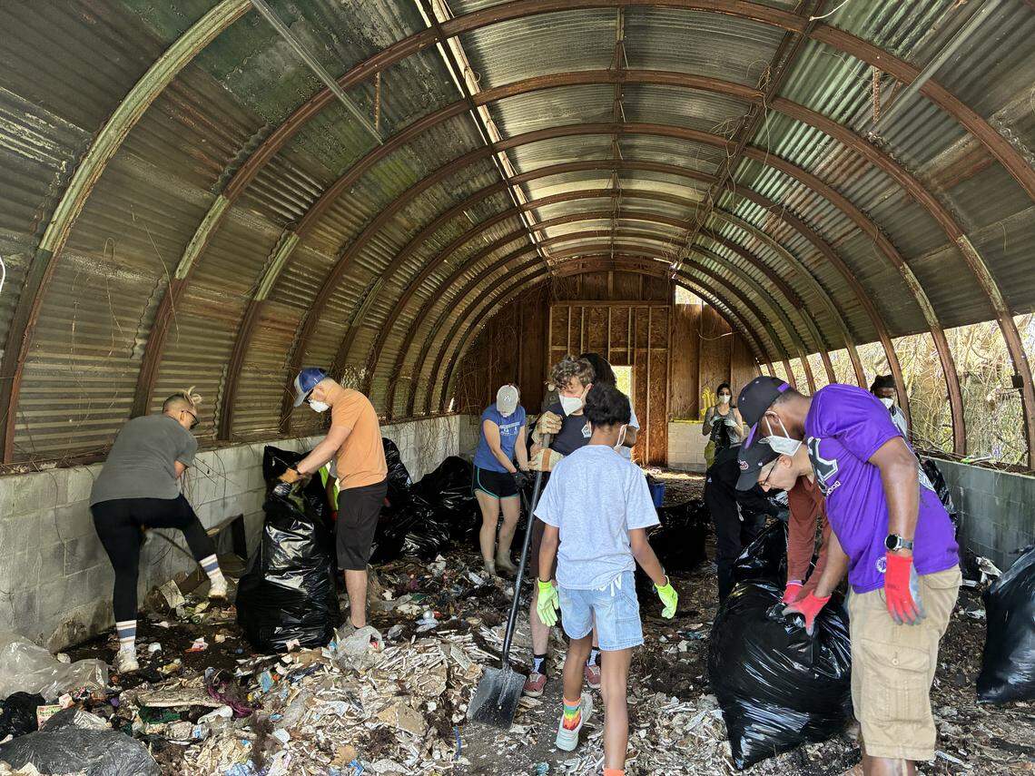 Volunteers haul away trash during a Living Mosaic Collective cleanup in March 2026 on Warm Springs Road. in Columbus.