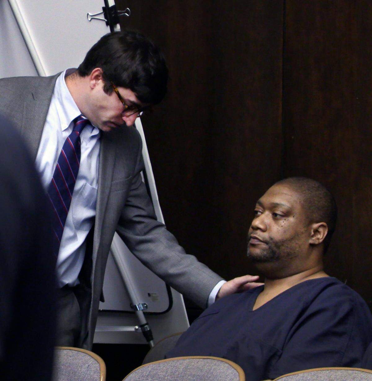 Bentley Adams IV, standing left, speaks with his client Antonio Bernard “Tony” Willis after Willis was sentenced Wednesday to 30 years in prison by Superior Court Judge Gil McBride. 01/04/2023