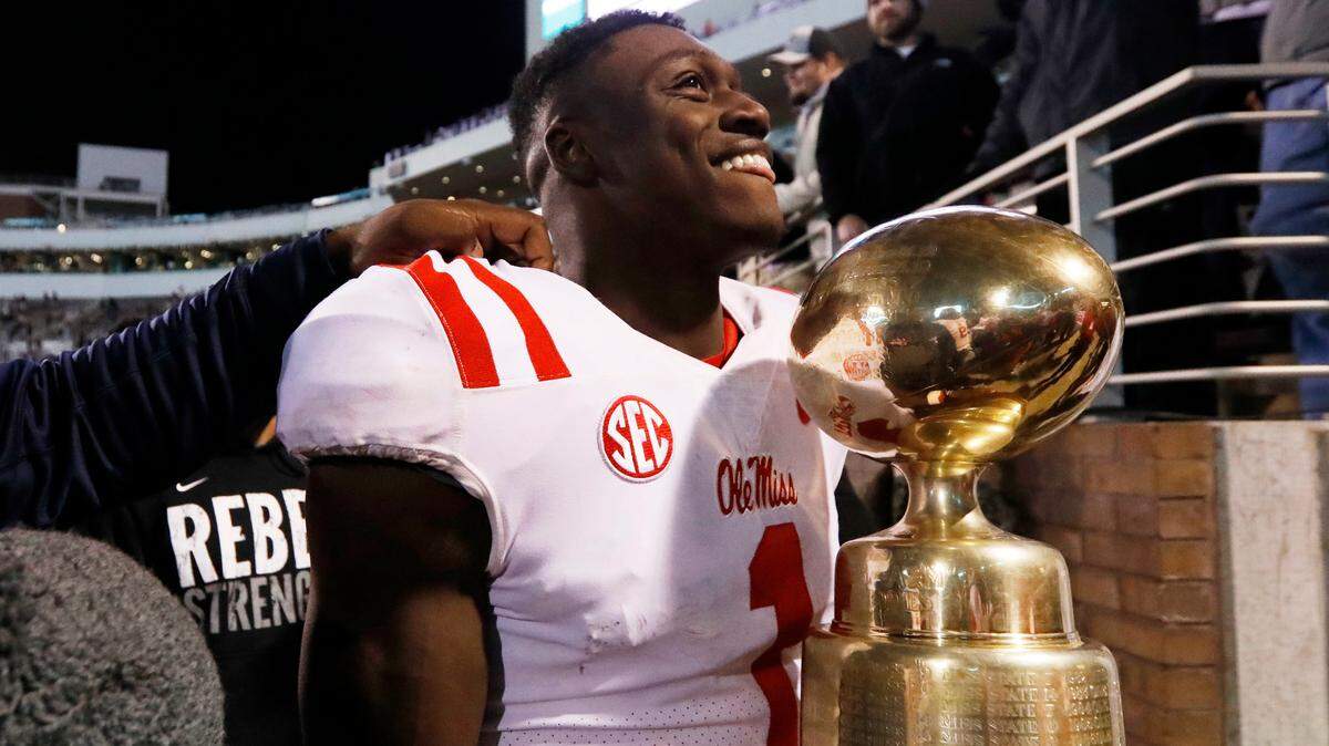 Mississippi wide receiver A.J. Brown carries the Egg Bowl trophy following the team's 31-28 win over Mississippi State on Nov. 23, 2017.