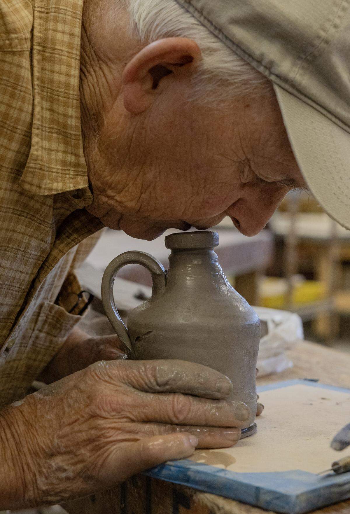 Folk potter Ned Berry blows into a jug to help shape it while making pottery at Britt David Studio in Columbus on April 14, 2026.