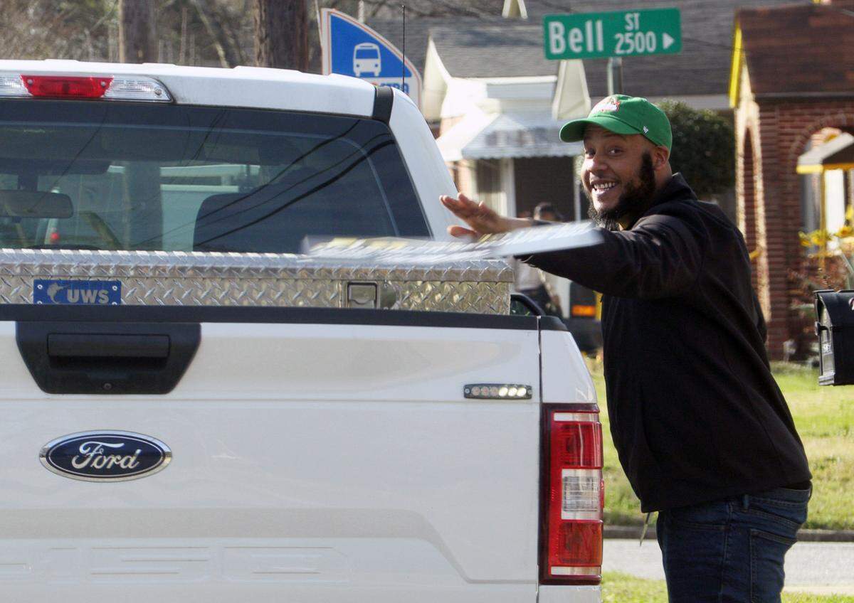 A Columbus city employee throws a sign into a work truck he removed from a city right of way Thursday morning as part of the first “Operation Illegal Sign Roundup Campaign.” 02/27/2025
