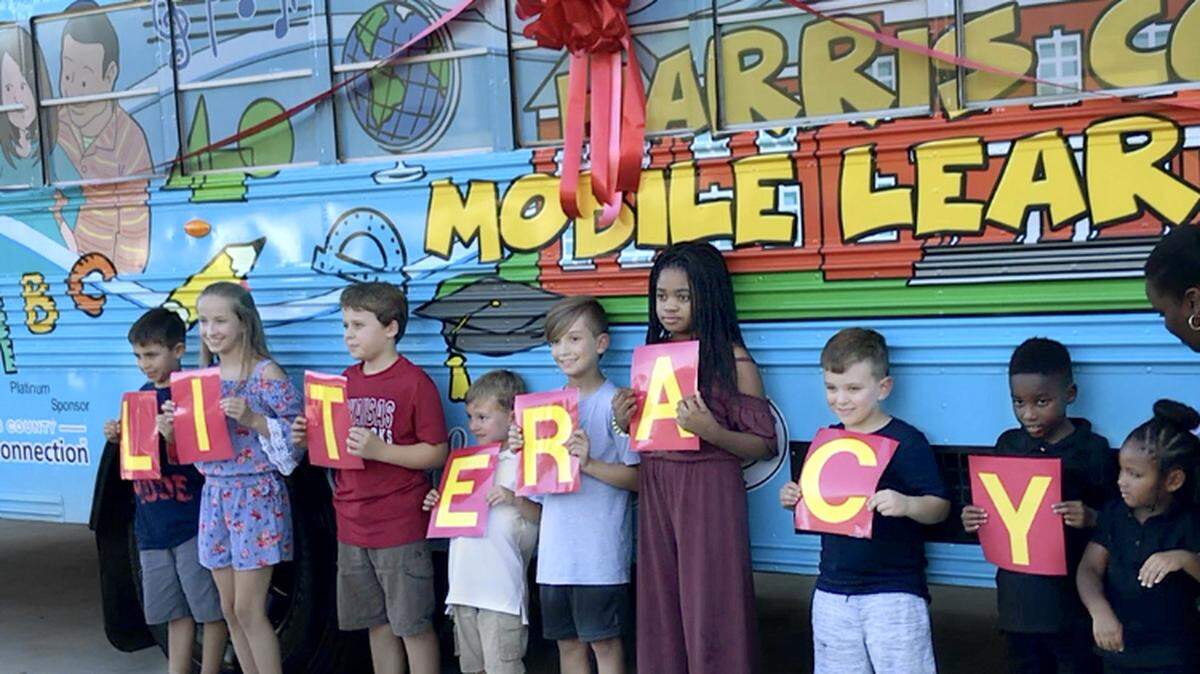 Students, faculty and county officials cut the ribbon on the Mobile Learning Lab to promote literacy, college professional career assistance in Harris County.