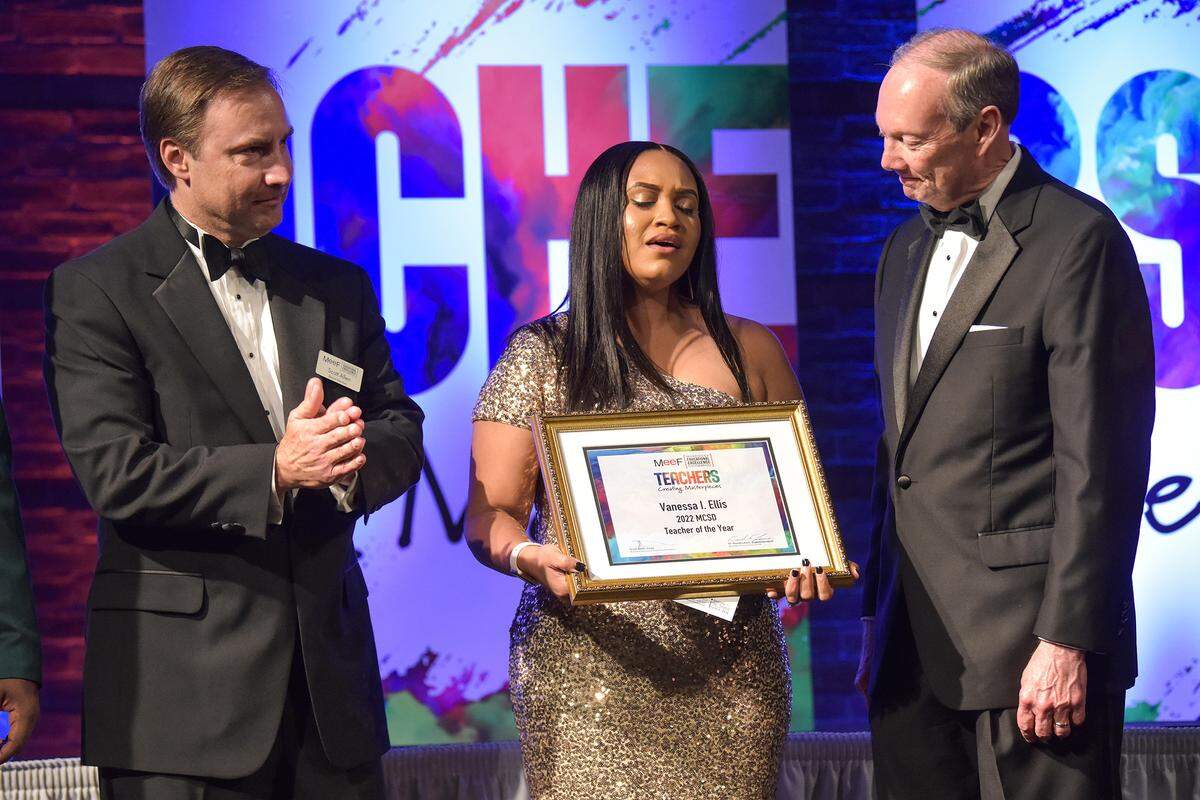 Muscogee Educational Excellence Foundation chairman Scott Allen, left, and David Lewis, superintendent of the Muscogee County School District present Vanessa Ellis, a teacher at Veterans Memorial Middle School with the 2022 MCSD Teacher of the Year award Thursday evening at the Columbus Convention and Trade Center in Columbus, Georgia. 05/05/2022
