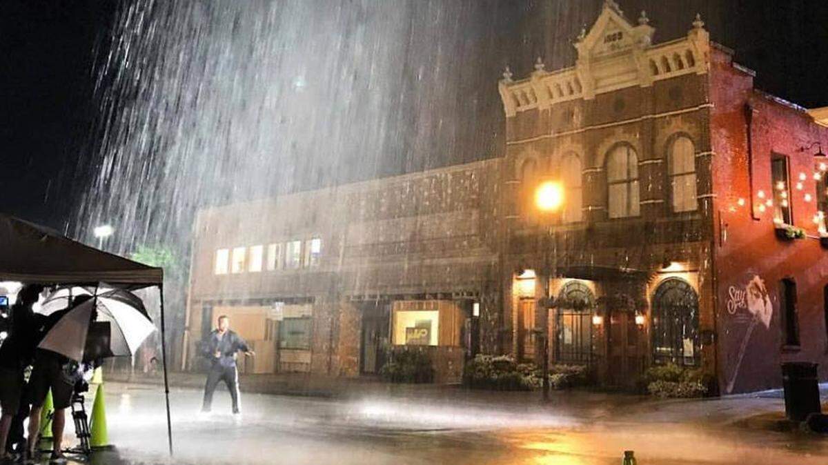 A crew from the upcoming faith-based movie, “My Brother’s Keeper,” shoots a dramatic, rainy scene on Eleventh Street in downtown Columbus in late June. The buildings in the background include the popular restaurant Mabella’s, just off Broadway. --