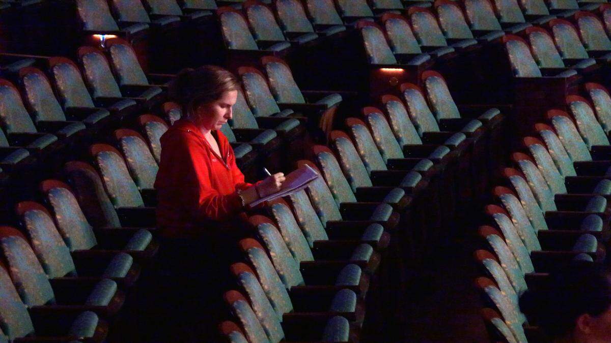 Victoria Hall takes notes during a dress rehearsal of “A Christmas to Believe In” at RiverCenter for the Performing Arts in Columbus, Georgia.