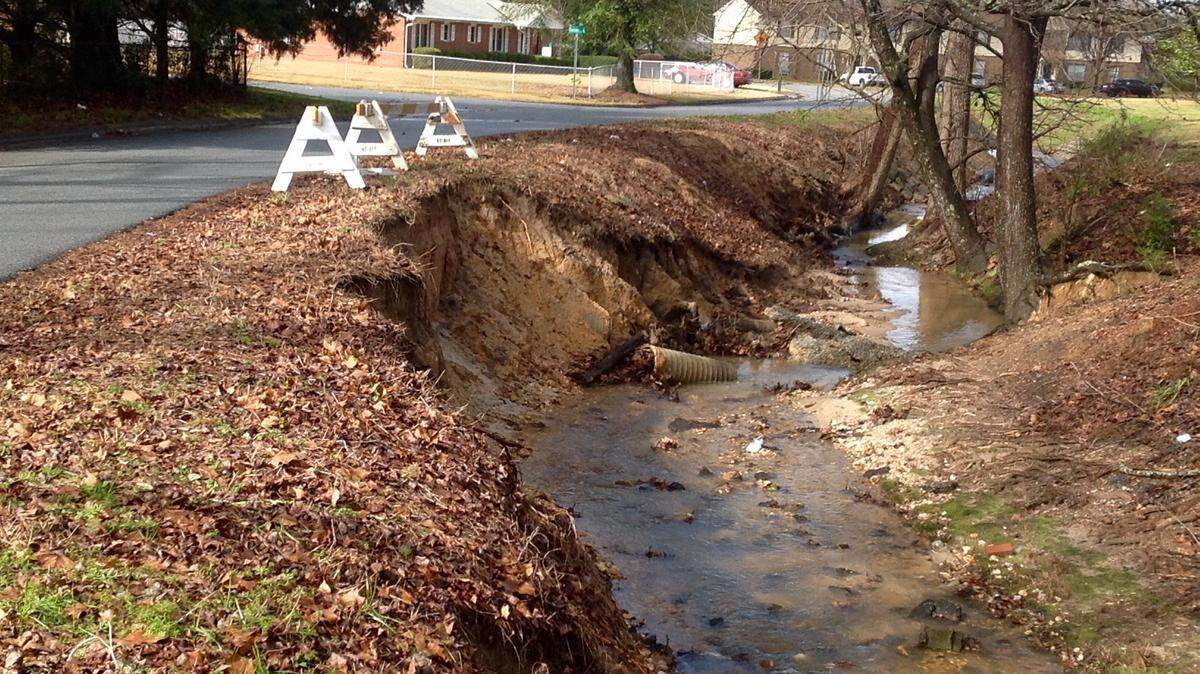 Mike Owen/mowen@ledger-enquirer.comA large chunk of the bank of this drainage ditch along Booth Street is missing, but repairs are on the way, officials say.