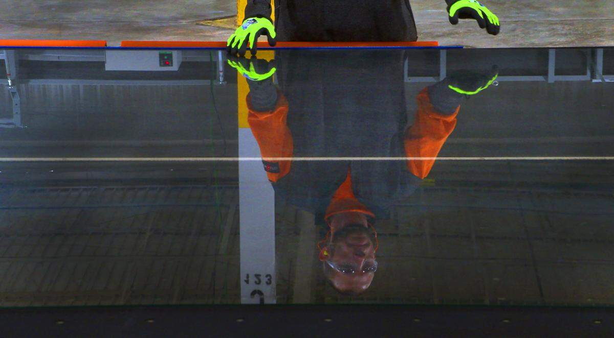 A worker watches a large sheet of glass as it comes down the production line prior to being cut at Sierra Pacific Windows’ newest location in Phenix City, Alabama. 10/22/2024