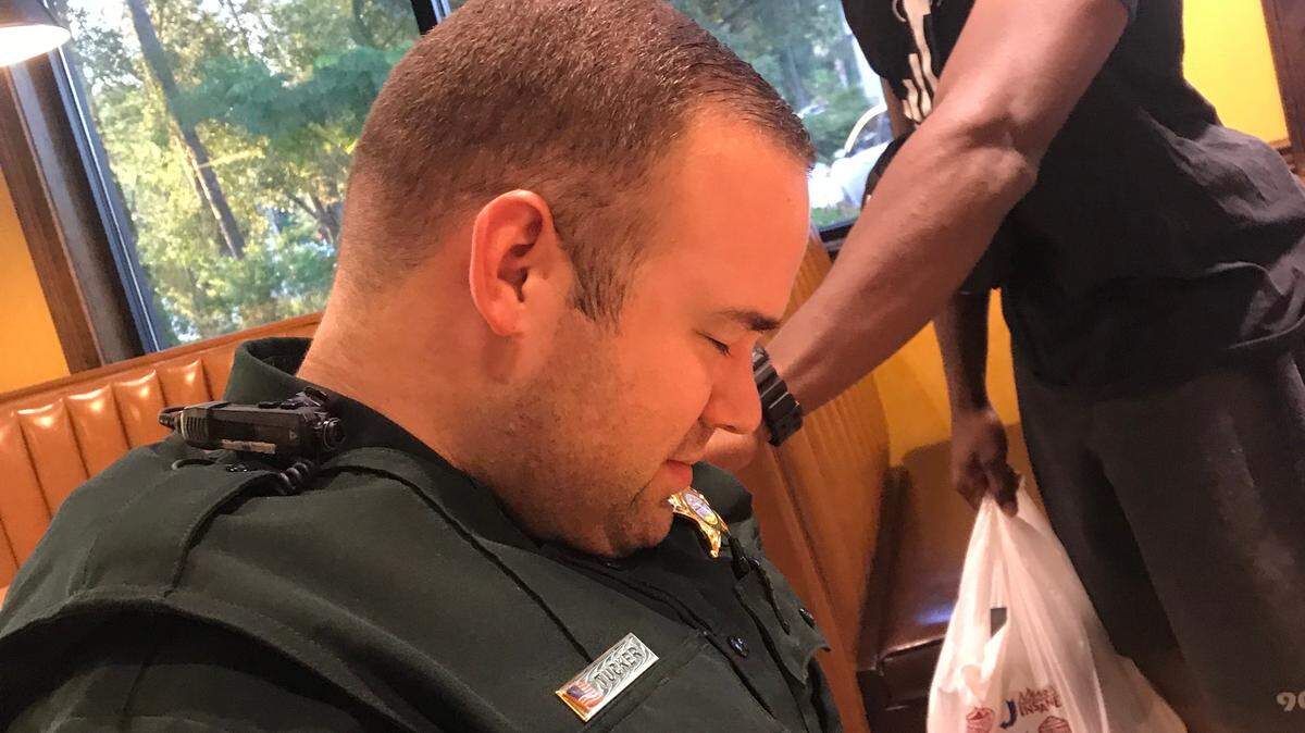 On Sept. 21, 2019, Harris County High School graduate Juan O’Neal, now a senior at Stetson University, blesses Volusia County Sheriff’s Office sheriff’s deputy Cameron Tucker at a Zaxby’s in Deland, Florida.