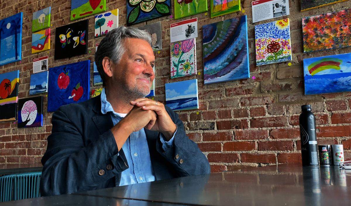 Bo Bartlett sits in front of several pieces of art that will be showcased at The Home Is Where The Art exhibition featuring work from people experiencing homelessness in Muscogee County. 04/26/2023